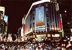 4丁目の交差点に立ち、三越前のステージに注目するお客様